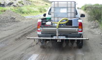 Mobile dust suppression unit treating a gravel road